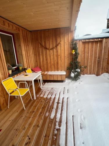 a room with a table and chairs in the snow at Stadtfüchse plus Sauna in Bad Ischl