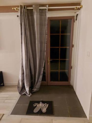 une porte menant à une chambre avec un tapis devant une porte dans l'établissement Studio loué entier proche de Paris, à Ecquevilly