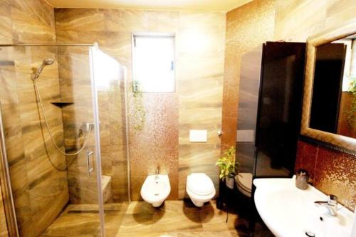 uma casa de banho com um WC, um lavatório e um chuveiro em Seaview Pool Villa with cinema up to 26 em Kaštela
