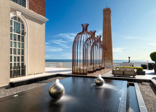 a view of a building with a fountain with two vases at Kaya Palazzo Resort & Casino in Kérynia
