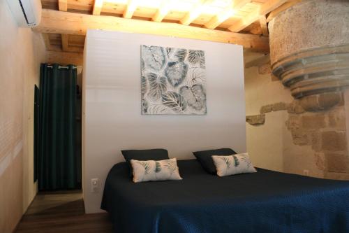 a bed in a room with a painting on the wall at Les Gîtes de Genas in Bourg-lès-Valence