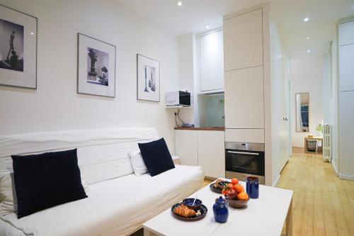 un salon avec un canapé blanc et une table dans l'établissement Paris - Tournelles - Place des Vosges, à Paris