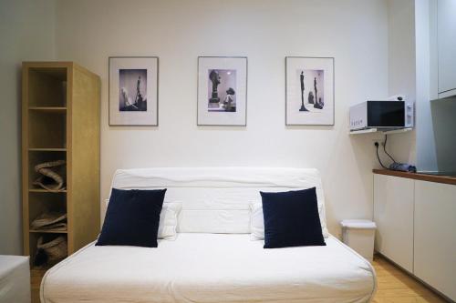 - une chambre avec un lit blanc et des photos sur le mur dans l'établissement Paris - Tournelles - Place des Vosges, à Paris