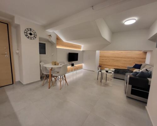 een woonkamer met een tafel en een klok aan de muur bij Athens Cosy Semi-Basement Apartment in Athene