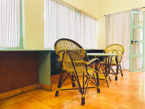 three chairs and a table in a room at Punarjani Ayurvedic Resorts in Ramakkalmedu