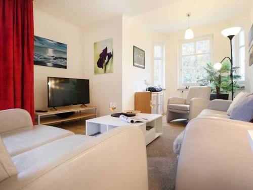een woonkamer met witte meubels en een flatscreen-tv bij Deutsches Haus Whg DH8 in Boltenhagen