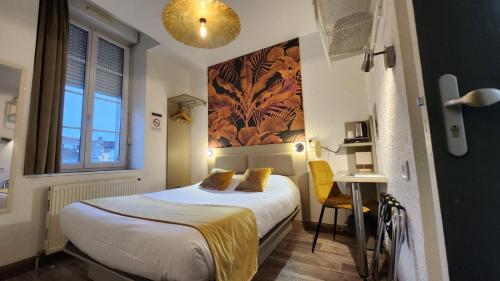 Pokój hotelowy z łóżkiem i biurkiem w obiekcie Cit'Hotel Le Cheval Blanc Cognac Centre w mieście Cognac