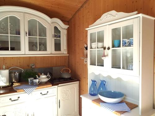 a kitchen with white cabinets and a bowl on a counter at Fantazja Letnia in Stegna