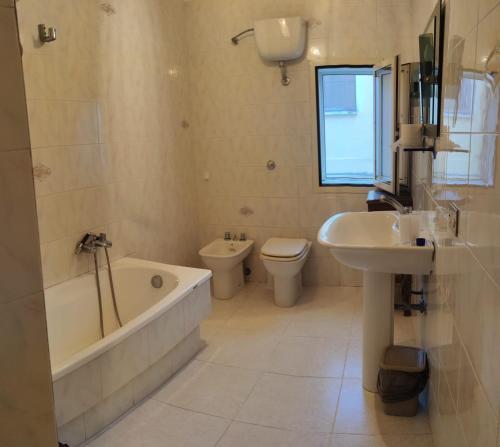 un bagno con vasca, WC e lavandino di SOPRAMARE APPARTAMENTO a Rodi Garganico