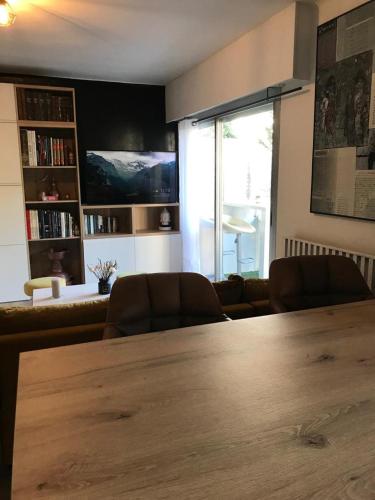 ein Wohnzimmer mit einem großen Holztisch und Stühlen in der Unterkunft La Petite Suite in Cannes