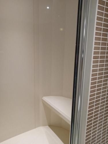 a white bathroom with a shower and a glass door at Holiday Inn Dumfries by IHG in Dumfries
