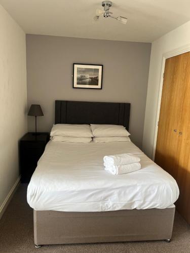 a bed with two towels on it in a bedroom at Century Wharf Apartments by Urban Space in Cardiff