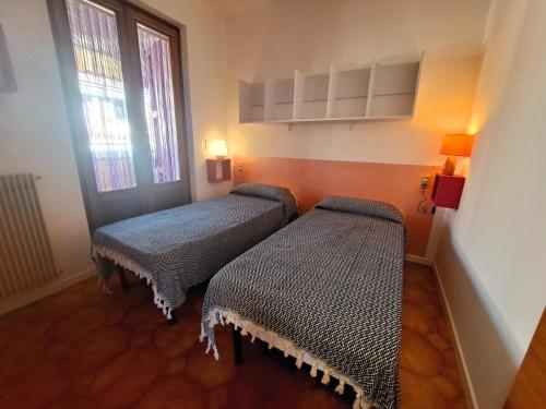 Habitación pequeña con 2 camas y ventana en Casa Salieri, en Garda