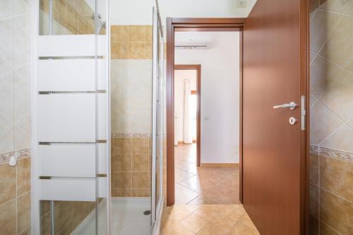 baño con ducha y puerta de cristal en Is Lais appartamento 2, en Masainas