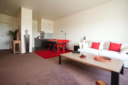 un salon avec un canapé blanc et une table dans l'établissement Biarritz - le Regina - proche phare, à Biarritz