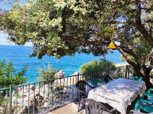 einen Tisch und Stühle auf einem Balkon mit Meerblick in der Unterkunft Luxury Seaside Holm Oak Villa with Private Beach in Bar