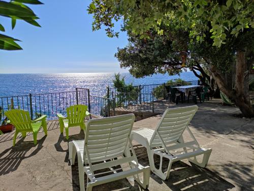 a group of chairs sitting next to the ocean at Luxury Seaside Holm Oak Villa with Private Beach in Bar
