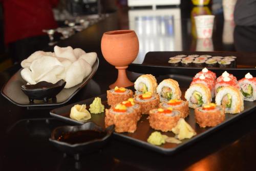 einen Tisch mit zwei Tabletts Sushi und einem Teller in der Unterkunft ACE KITE HOTEL in Çomaklı