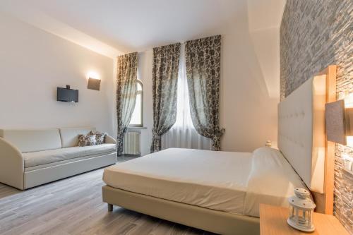 a hotel room with a bed and a couch at Hotel Il Buongustaio in Massa