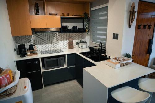 a kitchen with black cabinets and a white counter top at Tinker's Cabin Baguio in Baguio