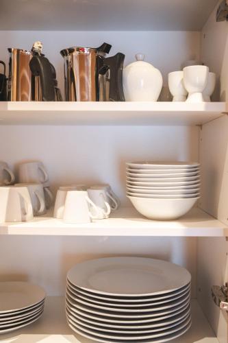a shelf filled with plates and cups and dishes at Elslerhof in Dobbiaco
