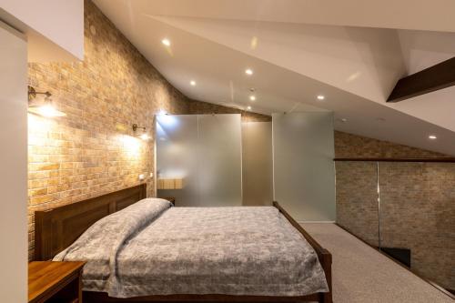 a bedroom with a bed and a brick wall at Hotel-Restaurant Complex Vensky in Brovary