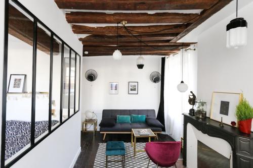 un salon avec un canapé et un lit dans l'établissement Paris, Bastille, Style atelier d artiste, à Paris