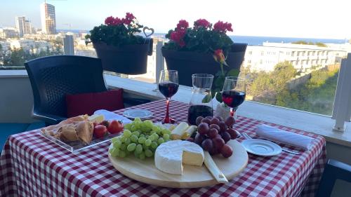 un tavolo con un piatto di cibo e bicchieri di vino di St. Julian's Super Bright And Spacious Seaview Apartment a San Giuliano