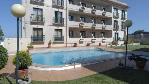 a hotel with a swimming pool in front of a building at Hotel Oca Vermar in Aios