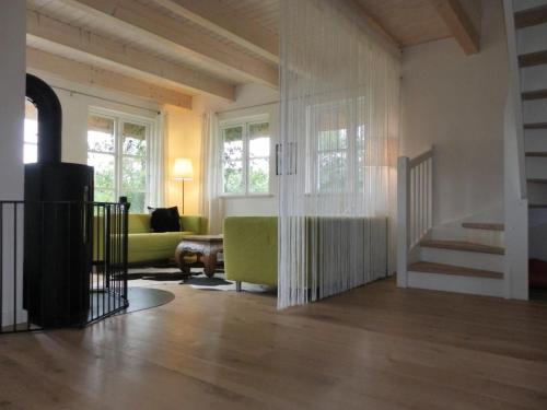 a living room with a green couch and a staircase at Ferienhaus Fritid in Groß Schwansee