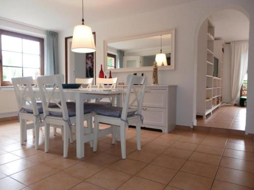 a dining room with a white table and chairs at Fischerhaus Whg Sommerbrise in Neukloster
