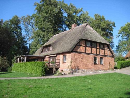 a large brick house with a thatched roof at Fischerhaus Whg Sonnenaufgang in Neukloster