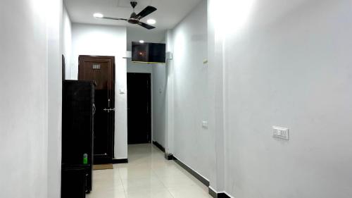 een hal met witte muren en een plafondventilator bij SHIV SNEH HOME STAYS in Ujjain
