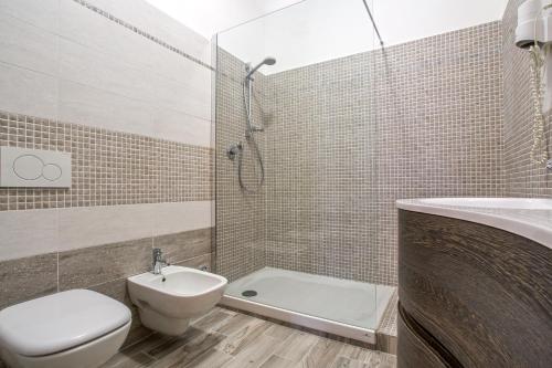 a bathroom with a toilet and a sink and a shower at Hotel Il Buongustaio in Massa