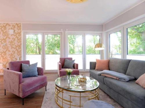 ein Wohnzimmer mit einer Couch und zwei Stühlen und einem Tisch in der Unterkunft Gezeiten App 3 Goldrichtig in Boltenhagen