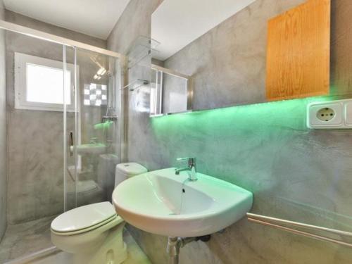 a bathroom with a white sink and a toilet at Villa with pool and sea views in Sant Josep de Sa Talaia