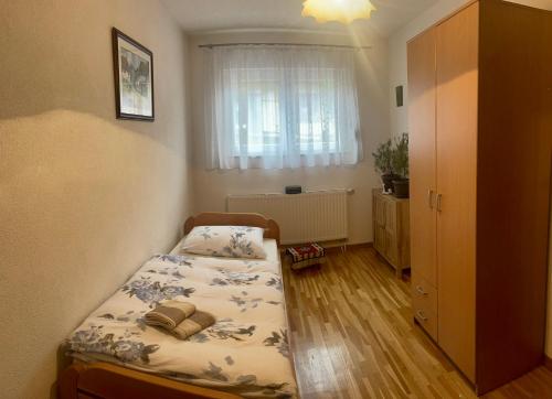 a small bedroom with a bed and a window at Apartment Milkica in Sarajevo