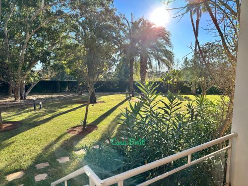 une vue d'un parc avec des palmiers et une clôture dans l'établissement Casa Brût - OLIVA NOVA, à Oliva