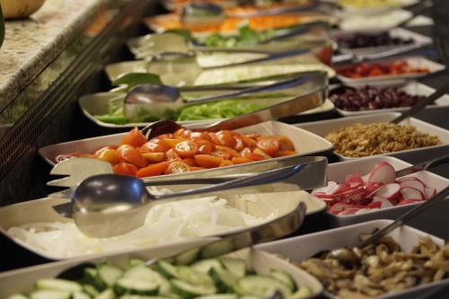 a buffet filled with different types of food in trays at Cactus Royal Spa & Resort Adults Only in Stalida