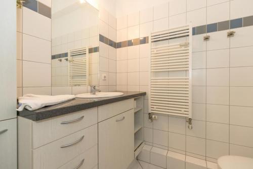 ein weißes Badezimmer mit Waschbecken und Toilette in der Unterkunft Villa Parkblick in Kühlungsborn