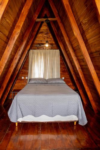 a bed in the attic of a wooden cabin at CHALE DAS ESTRELAS in Piçarras