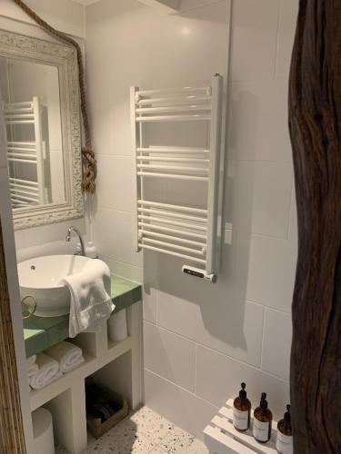 a white bathroom with a sink and a mirror at Meerpaal 43 Bergen in Bergen
