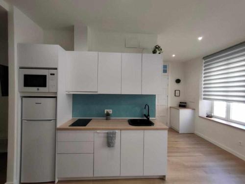 kuchnia z białymi szafkami i zlewem w obiekcie Apartamento Parras w Maladze