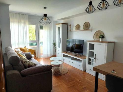 a living room with a couch and a flat screen tv at La Marina Posada de LLanes VUT-3648-AS in Posada de Llanes