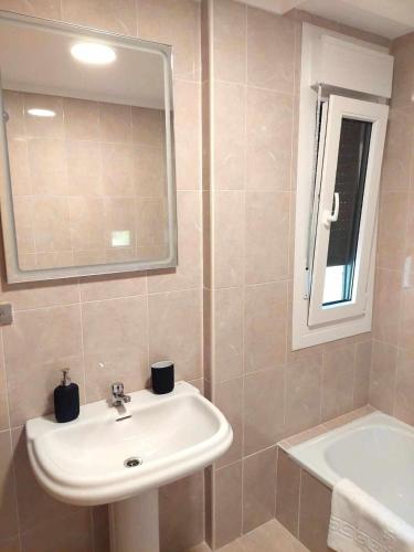 a bathroom with a sink and a mirror and a tub at La Marina Posada de LLanes VUT-3648-AS in Posada de Llanes