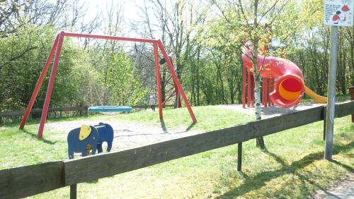 un parque con parque infantil con columpios en Marja Ferienwohnung en Oberorke