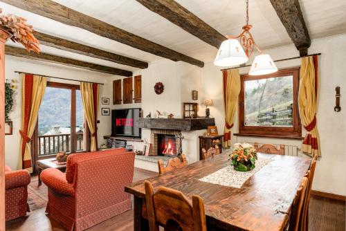 uma sala de jantar com uma mesa e uma lareira em 5 min Piste Sci, Garage - Ski House Prerichard em Bardonecchia