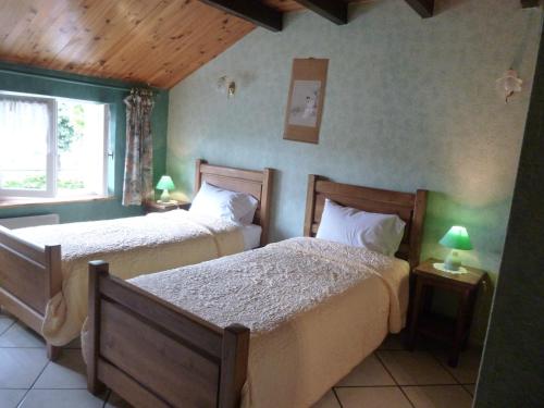 a bedroom with two beds and a window at Les Chambres De Solgne in Solgne