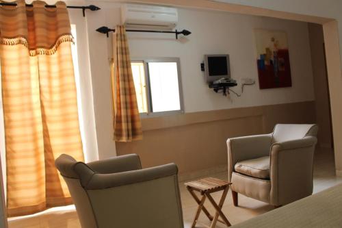 a living room with two chairs and a window at Pelican Residence in Fajara