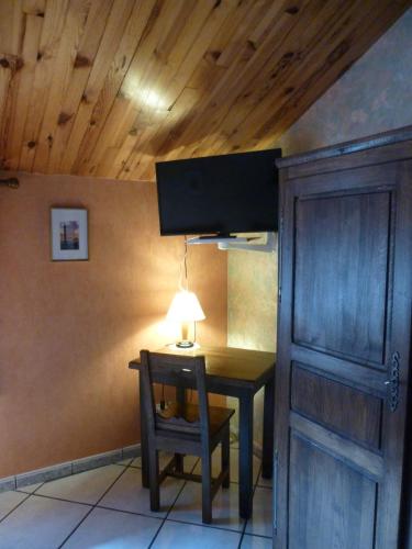 a table with a lamp and a chair in a room at Les Chambres De Solgne in Solgne